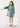Vestido verde Mayoral para menina com estampado de menina e flores na parte frontal.