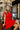 Vestido vermelho Silvina Campos com decote cruzado e detalhe dourado.