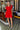 Vestido vermelho Silvina Campos com decote cruzado e detalhe dourado.