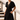 Vestido curto preto da marca Scusi com decote em V e manga fluida, usado por modelo em ambiente exterior.