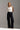 Jeans femininos Ferrache de cintura subida e perna larga em mistura de algodão, com cinco bolsos, costuras contrastantes e fecho frontal.