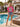 T-shirt rosa feminina com estampa artística de palmeira colorida em estilo tropical.
